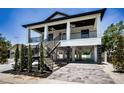 Charming two-story home with a covered porch, black railings, and convenient ground floor parking at 111 E Cedar St, Tarpon Springs, FL 34689