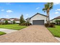 Charming single-story home with a well-kept lawn, mature landscaping, and a welcoming brick-paved driveway at 11398 Juglans Dr, Odessa, FL 33556