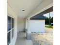 Home porch featuring sleek white columns and a view of surrounding landscape at 11406 Labrador Duck Rd, Weeki Wachee, FL 34614