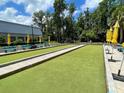 Bocce ball court with lush green turf, surrounded by benches and umbrellas for a relaxing day outdoors at 11619 Boynton Ln, New Port Richey, FL 34654