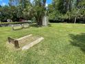 Enjoy outdoor games at the horseshoe pit featuring benches, lush green grass, and a storage shed at 11619 Boynton Ln, New Port Richey, FL 34654