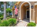 View of the house with decorative plants and an American flag flying near the front door at 11752 Wheatfield Loop, Hudson, FL 34667