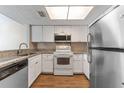 Bright kitchen features white cabinets, stainless steel appliances, and granite countertops at 12155 Environmental Dr # 8, New Port Richey, FL 34654