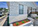 Close-up of a white brick home's landscaped front yard with red mulch and lush plants at 124 Athens St, Tarpon Springs, FL 34689