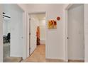 Hallway featuring an open door view to a bathroom, neutral paint and tile flooring at 13454 Golden Lime Ave, Spring Hill, FL 34609