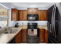 Functional kitchen with wood cabinets, black appliances, and ample counter space at 13923 Pathfinder Dr, Tampa, FL 33625