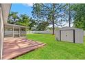 Spacious backyard features a screened patio, storage shed, and lush lawn at 13935 Coronado Dr, Spring Hill, FL 34609