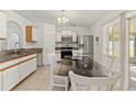 Eat-in kitchen features modern appliances, white cabinets, and a large sliding glass door at 13935 Coronado Dr, Spring Hill, FL 34609