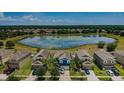 Aerial view of a blue home featuring a pond, lush landscaping, and a beautiful neighborhood at 14008 Lugano Ct, Hudson, FL 34669