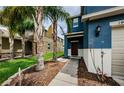 Two-story blue home featuring a front entrance with walkway, landscaping, and exterior lighting at 14008 Lugano Ct, Hudson, FL 34669