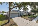 Well-maintained home with a two-car garage, complemented by a lush green lawn and mature trees at 15159 Durango Cir, Brooksville, FL 34604