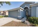 Close-up of gray home showing two car garage, the front door, and well maintained landscaping at 15159 Durango Cir, Brooksville, FL 34604