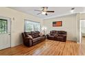 Cozy living room with hardwood floors, a ceiling fan, and comfortable seating furniture at 15613 Charmwood Dr, Hudson, FL 34667