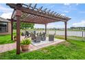 Enjoy outdoor living with a pergola-covered patio overlooking a serene lake and manicured lawn at 1760 Fox Grape Loop, Lutz, FL 33558