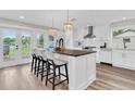 Modern kitchen features white cabinets, a large island with seating, and lake views at 18102 Spencer Rd, Odessa, FL 33556