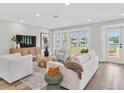 Bright living room boasts ample seating and serene lake views through French doors at 18102 Spencer Rd, Odessa, FL 33556