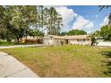 Spacious front yard showcasing a well-maintained lawn and the home's charming single-story exterior at 22154 Weeks Blvd, Land O Lakes, FL 34639