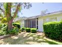 Well-manicured backyard featuring a screen-enclosed porch and lush landscaping at 2836 Featherstone # 2836, Holiday, FL 34691