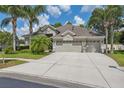 Stunning home boasts a spacious driveway, three-car garage, and beautiful desert landscaping at 3243 Stonegate Falls Dr, Land O Lakes, FL 34638