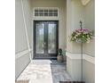 Elegant front entrance featuring double doors, decorative window, and a welcoming 'Bienvenue' doormat at 3243 Stonegate Falls Dr, Land O Lakes, FL 34638