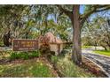 Community entrance with sign for Beacon Lakes Private Way, lush landscaping, and mature trees at 3838 Lanyard Ct # 3838, New Port Richey, FL 34652