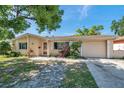 Well-maintained single-story home with a welcoming front yard and attached garage for convenient parking at 4025 Stratfield Dr, New Port Richey, FL 34652