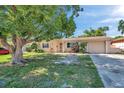 Inviting single-story home with a lush front yard and mature tree providing shade and curb appeal at 4025 Stratfield Dr, New Port Richey, FL 34652