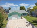 Aqua home featuring a paver driveway, a white garage door, and a well-maintained lawn at 4482 Kingston Dr, Hernando Beach, FL 34607