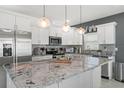 Modern kitchen with granite countertops, stainless steel appliances, and elegant pendant lighting at 5328 Baldock Ave, Spring Hill, FL 34608