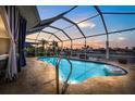 Inviting screened-in pool with waterfront views, lush landscaping, and relaxing patio furniture at 5340 Pilots Pl, New Port Richey, FL 34652
