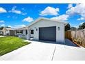 Charming single-story home featuring a gray exterior, attached garage, and well-maintained lawn at 6306 Aberdeen Ave, New Port Richey, FL 34653