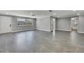 Spacious living room with sleek gray tile flooring, recessed lighting, and neutral gray wall color throughout at 6306 Aberdeen Ave, New Port Richey, FL 34653