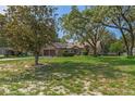 Lovely single-story home with a spacious front yard, shaded by mature trees, offering a serene setting at 8402 Lake Hill Ct, Spring Hill, FL 34608