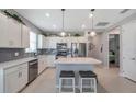 Bright kitchen featuring stainless steel appliances, a center island with seating, and white cabinetry with modern fixtures at 8431 Ocean Tides Cv, Parrish, FL 34219