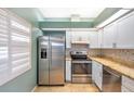 Bright kitchen featuring stainless steel appliances, white cabinets, and stone countertops at 9212 Estrada Pl, New Port Richey, FL 34655