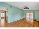 Spacious living room with wood floors, ceiling fan and sliding glass doors to an enclosed lanai at 9212 Estrada Pl, New Port Richey, FL 34655
