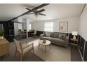 Bright living room showcasing modern furniture, a ceiling fan, and large windows for natural light at 9444 Loras St, New Port Richey, FL 34654