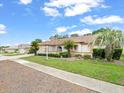 Lovely one-story home featuring lush landscaping, mature trees, and a well-maintained lawn at 10442 Ventura Dr, Spring Hill, FL 34608