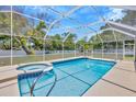 Beautiful screened-in pool area featuring a large pool, spa, and patio space at 11291 Countrywood Ct, Spring Hill, FL 34609