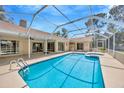 Beautiful screened-in pool area featuring a large pool, spa, and patio space at 11291 Countrywood Ct, Spring Hill, FL 34609