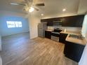 Well-lit kitchen boasts stainless steel appliances, dark wood cabinets, and durable wood-look flooring at 11392 Beechdale Ave, Spring Hill, FL 34608