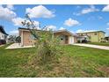 Single-story home with a brick facade, turquoise shutters, and a well-manicured lawn at 12637 2Nd Isle, Hudson, FL 34667