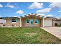 Lovely single-story home boasts a brick exterior, bright turquoise shutters, and a neatly paved driveway at 12637 2Nd Isle, Hudson, FL 34667