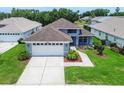 Beautiful single-story home with a well-manicured front yard, driveway, and blue exterior at 14011 Shoal Dr, Hudson, FL 34667
