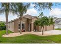 Inviting single-story home featuring a landscaped front yard with gravel, mature trees, and a cozy entryway bench at 2526 Brinley Dr, Trinity, FL 34655