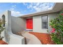 Stylish front entrance featuring a vibrant red double door and decorative rock landscaping at 3427 Charmwood Ave, Spring Hill, FL 34609