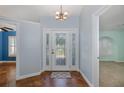 Bright foyer with decorative front door, tile flooring, and neutral paint, leading to other rooms at 3609 Montclair Dr, New Port Richey, FL 34655