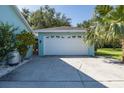 Spacious two-car garage featuring light blue exterior, a side entrance, and a wide concrete driveway at 3609 Montclair Dr, New Port Richey, FL 34655