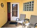 Inviting front porch featuring chairs, decorative wreath, and glass block window accents at 3627 Muirfield Ct # 3627, New Port Richey, FL 34655