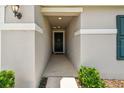 Inviting entryway featuring a covered porch, manicured bushes, and neutral tones creating a welcoming entrance at 3886 Reflection Dock Dr, Seffner, FL 33584